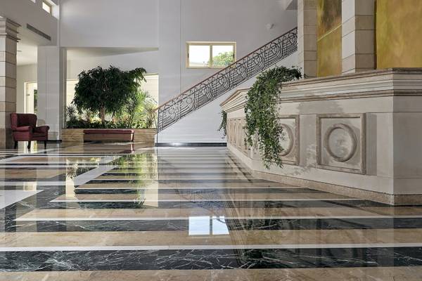 Foyer des Pilot Beach Resorts mit Marmorboden und geschwungener Treppe