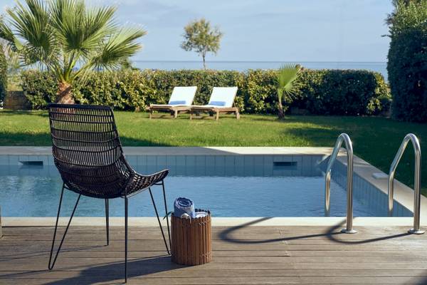 Lounge-Stühle neben dem Pool des Pilot Beach Resorts mit Blick auf das Meer