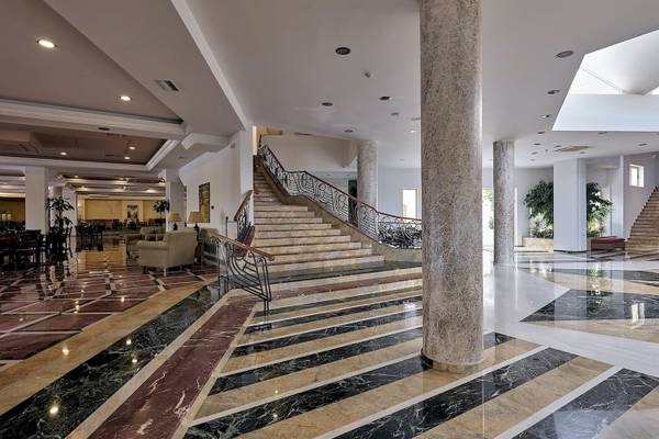 Hotel-Foyer mit einem großen Treppenhaus und Marmorsäulen im Pilot Beach Resort.
