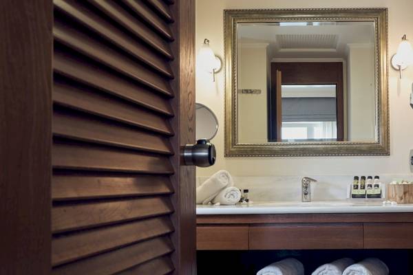 Badezimmer im Pilot Beach Resort mit Spiegel, Waschbecken und Handtüchern.