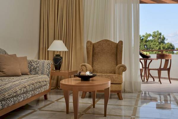 Wohnzimmer im Pilot Beach Resort mit Sofa, Sessel, Tisch und offener Veranda