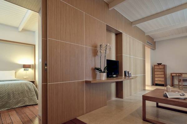 Innenansicht eines Hotelzimmers im Pilot Beach Resort mit Bett, Fernseher und Tisch
