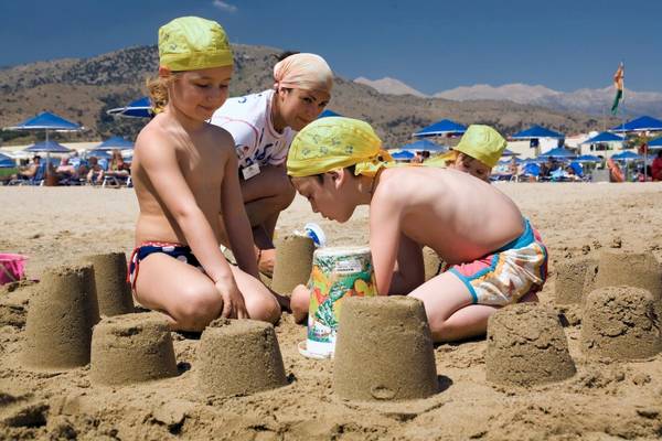 Kinder bauen Sandburgen am Strand des Pilot Beach Resorts