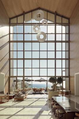 Innenbereich des Mare Paphos Hotels mit großen Fenstern, modernen Möbeln und Blick auf das Meer.