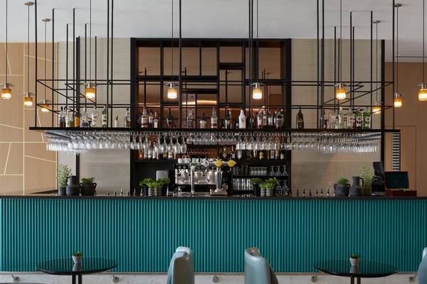 Innenansicht der Bar im Mare Paphos Hotel mit grüner Theke und schwarzen Stühlen.