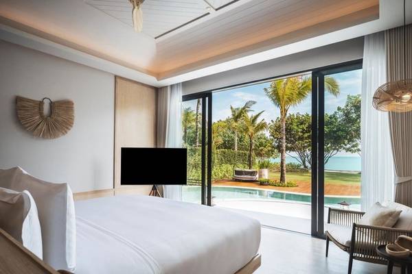 Schlafzimmer im Anantara Koh Yao Yai Resort mit Poolblick und modernen Möbeln.