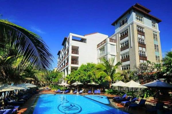 Außenbereich des Novela Muine Resort & Spa mit Swimmingpool, Liegestühlen und Sonnenschirmen.