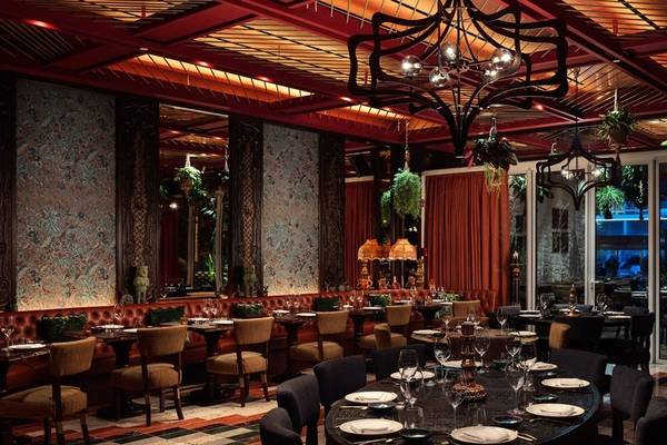 Innenraum des Restaurants im St. Regis Al Mouj Muscat Resort mit Tisch- und Stuhlarrangements.