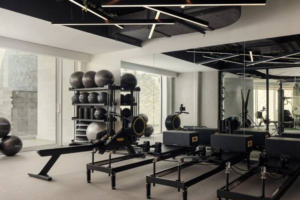 Fitnessstudio im St. Regis Al Mouj Muscat Resort mit Pilatesgeräten und Hanteln.