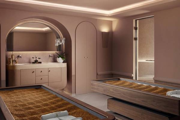 Spa-Behandlungsraum im St. Regis Al Mouj Muscat Resort mit zwei Behandlungsbetten und einer weißen Kommode.