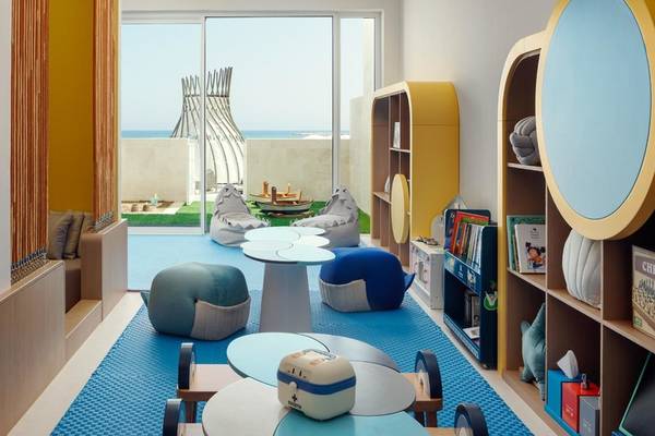 Kinderzimmer im St. Regis Al Mouj Muscat Resort mit bunten Möbeln und Spielzeug.