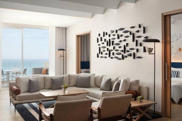Wohnbereich im St. Regis Al Mouj Muscat Resort mit Meerblick und modernen Möbeln.