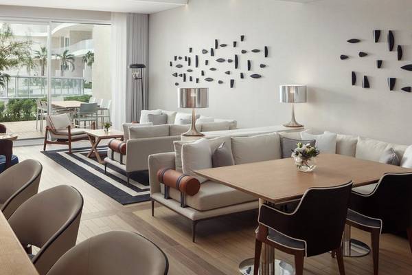 Loungebereich im St. Regis Al Mouj Muscat Resort mit weißen Möbeln und Dekoration.
