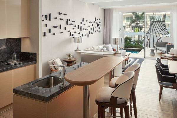 Wohnbereich im St. Regis Al Mouj Muscat Resort mit modernem Design, Sitzbereich und Küche.