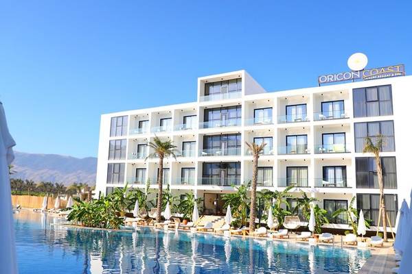 Außenansicht des Oricon Coast Luxury Resorts mit Swimmingpool und Sonnenliegen