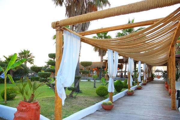 Außenbereich des Oricon Coast Luxury Resort mit hölzerner Pergola und weißen Vorhängen.