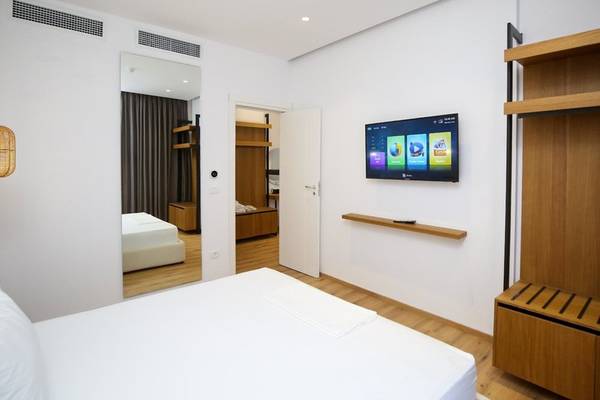 Schlafzimmer im Oricon Coast Luxury Resort mit Fernseher, Bett und Spiegel.