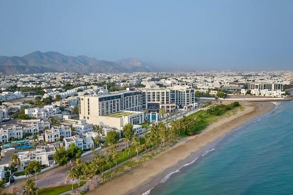 Luftaufnahme des Mandarin Oriental Hotels in Muscat mit Blick auf die Stadt, Berge und Strand