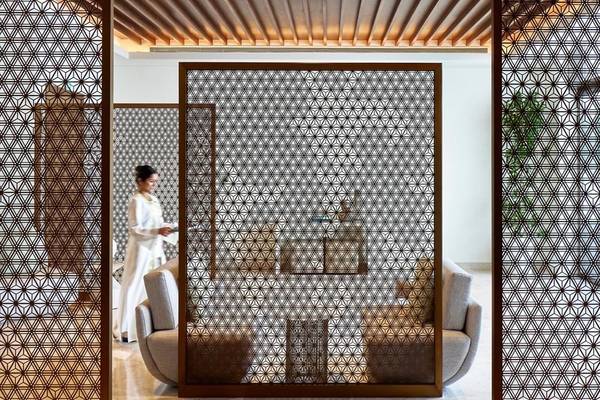 Loungebereich im Mandarin Oriental Hotel in Muscat mit modernen Möbeln und geometrischen Trennwänden.