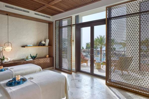 Behandlungsraum im Mandarin Oriental, Muscat, mit Blick auf eine Terrasse und Außenbereich.