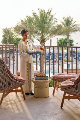 Frau serviert Getränke auf der Terrasse des Mandarin Oriental in Muscat