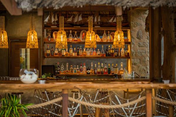 Bar des Les Lauriers Eco Hotel & Restaurant mit vielen Flaschen und Lampen