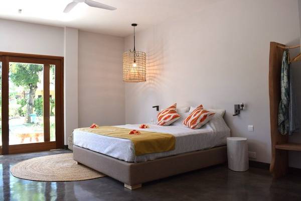 Schlafzimmer im Les Lauriers Eco Hotel & Restaurant mit Bett, Teppich und Glastür
