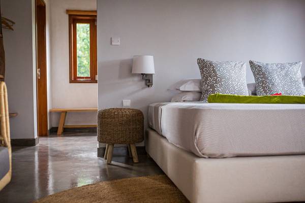 Schlafzimmer im Les Lauriers Eco Hotel & Restaurant mit Bett, Kissen, Lampen und Fenster