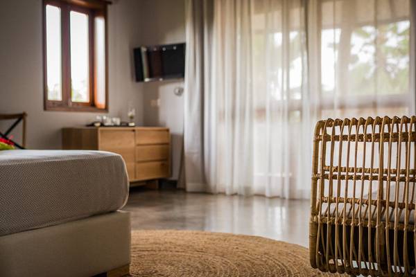 Ein Schlafzimmer im Les Lauriers Eco Hotel mit Bett, Nachttisch und Stuhl.