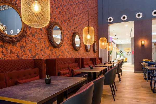 Innenbereich des Restaurants im Leonardo Royal Hotel Barcelona Fira mit runden Spiegeln und moderner Einrichtung.