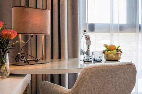 Zimmer im Leonardo Royal Hotel Barcelona Fira mit Tisch, Lampe und Obst