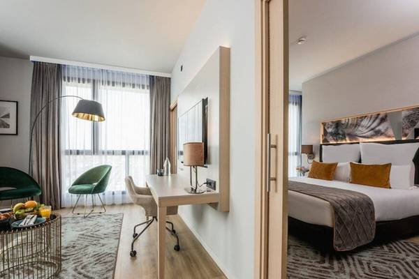 Hotelzimmer des Leonardo Royal Hotel Barcelona Fira mit Schreibtisch, Stühlen und Bett