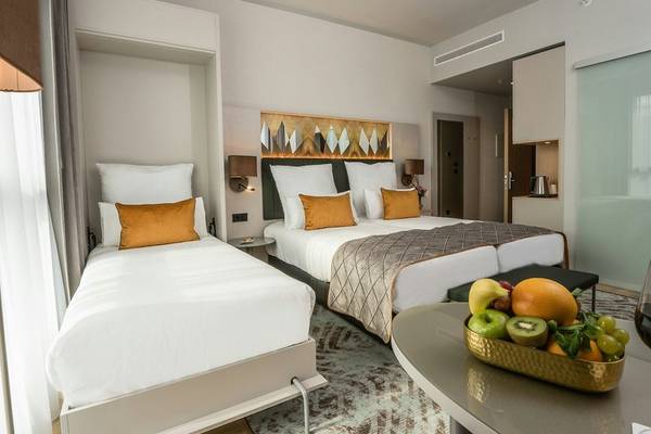 Doppelbett Zimmer im Leonardo Royal Hotel Barcelona Fira mit Früchteschal auf dem Tisch