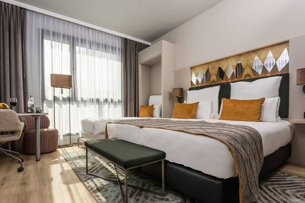 Doppelzimmer im Leonardo Royal Hotel Barcelona Fira mit zwei Betten, Dekor und Möbeln.