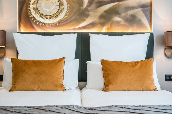 Doppelbett im Leonardo Royal Hotel Barcelona Fira mit Kissen und Lampen
