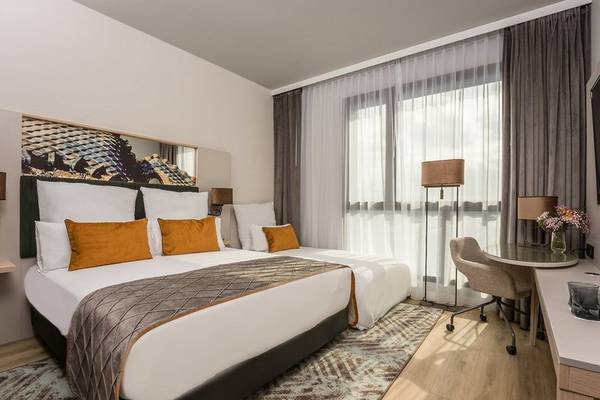 Schlafzimmer im Leonardo Royal Hotel Barcelona Fira mit zwei Betten, Dekor und Möbeln.