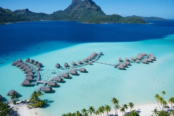 Luftaufnahme des Le Bora Bora by Pearl Resorts mit blauem Wasser und vielen Hütten