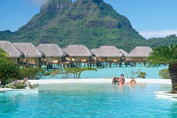 Le Bora Bora by Pearl Resorts: Zwei Personen entspannen im Pool mit Blick auf die Berglandschaft.