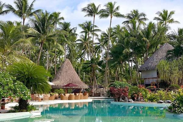 Poolbereich im Le Bora Bora Hotel mit Palmen und Lounge-Stühlen