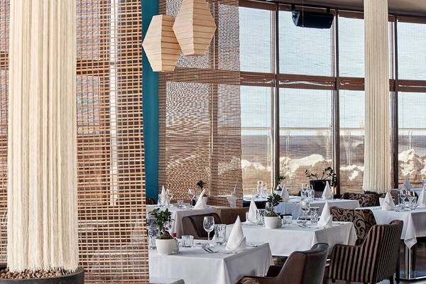 Innenansicht des Restaurants im Atlantica Caldera Palace mit blauen Wänden und großen Fenstern.