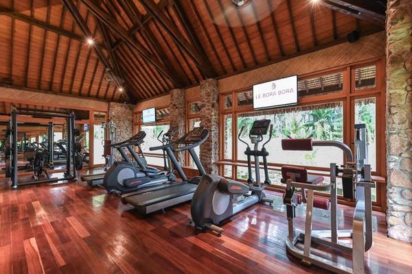 Fitnessstudio im Le Bora Bora Hotel mit Holzboden und modernen Geräten.