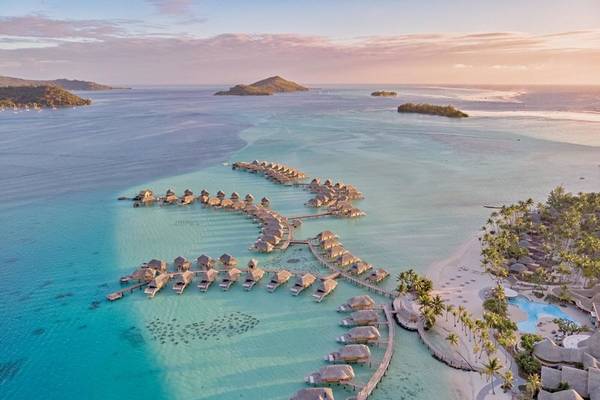 Luftaufnahme des Le Bora Bora by Pearl Resorts mit Wasserbungalows am Strand