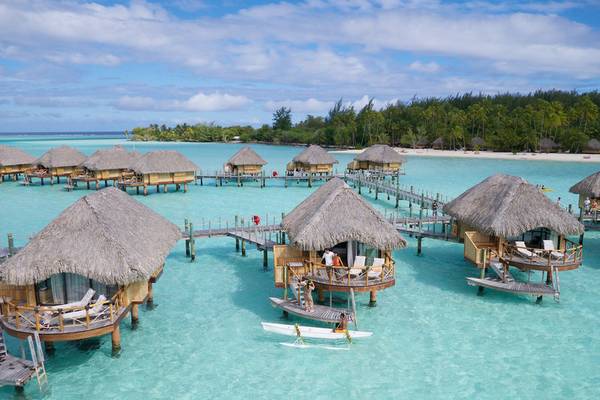 Luftaufnahme von Le Bora Bora by Pearl Resorts mit Überwasser-Bungalows und kristallklarem Wasser