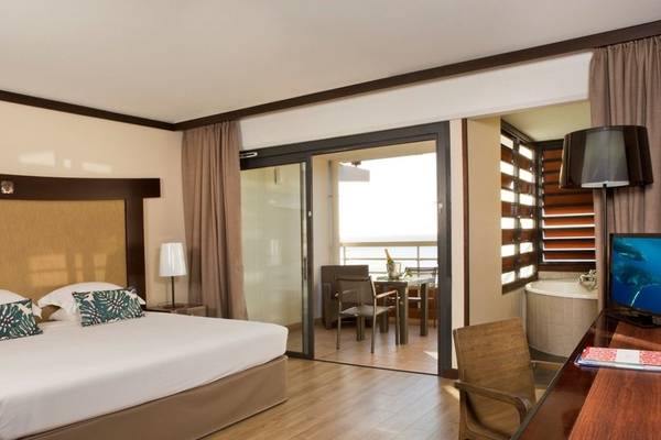 Hotelzimmer von Le Tahiti by Pearl Resorts mit Bett, Schreibtisch und Balkon.
