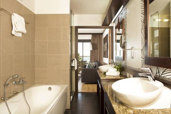 Badezimmer im Le Tahiti by Pearl Resorts Hotel mit Badewanne, Waschbecken und Toilette.