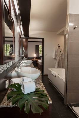 Badezimmer im Le Tahiti by Pearl Resorts mit zwei Waschbecken und einer Badewanne.
