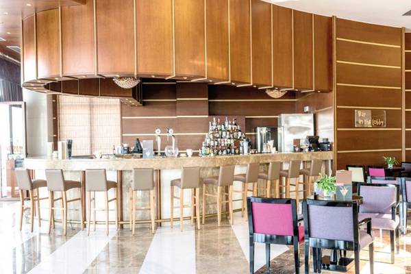 Lobby-Bar des Atlantica Caldera Palace Hotels mit Barhockern und Tischen.