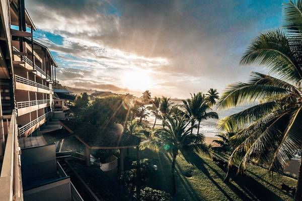 Aussicht vom Balkon des Le Tahiti by Pearl Resorts auf eine tropische Landschaft mit Palmen und einem Ozean