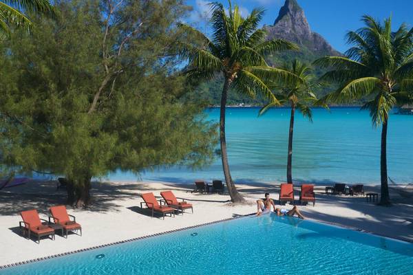 Poollandschaft des InterContinental Bora Bora Resort mit Blick auf den Berg und den Ozean.
