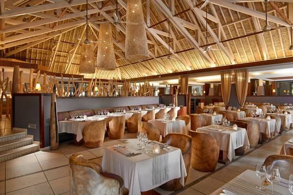 Innenbereich des Restaurants im InterContinental Bora Bora Resort and Thalasso Spa mit runden Holzstühlen und Tischen.